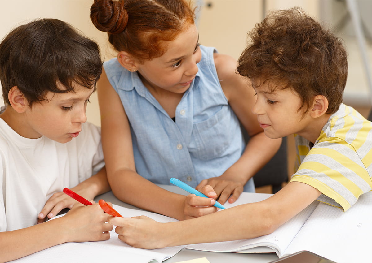 Three students working together at a desk.