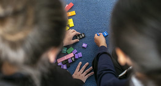 Student and teacher using math blocks.