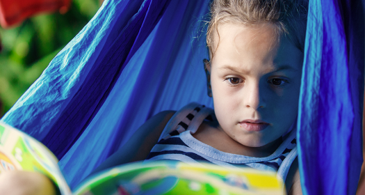 Girl reading in a hammock in summer.