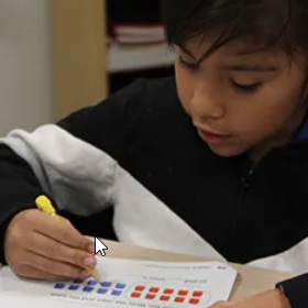 Young student completing a worksheet.