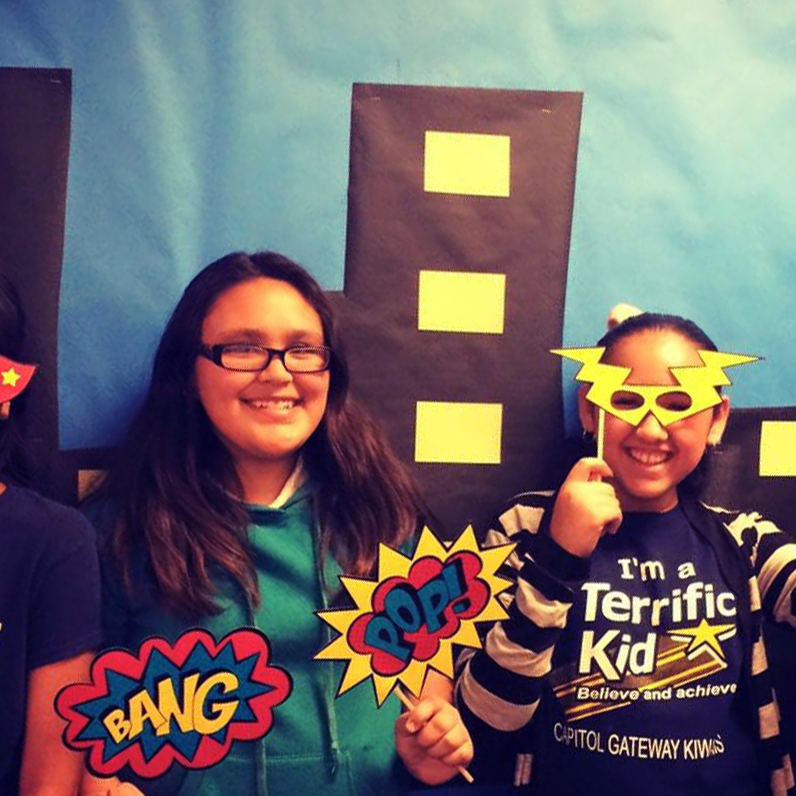 Students hold props for a celebratory photo together.