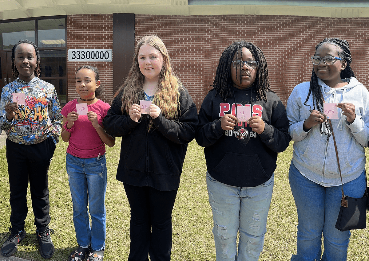 Students lined up in numerical order, arranging rational numbers from least to greatest.