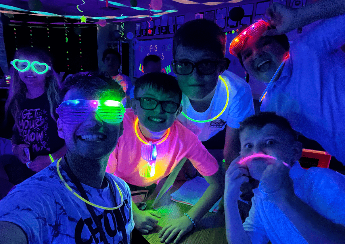 Students and their teacher celebrate success and connect during a glow party.