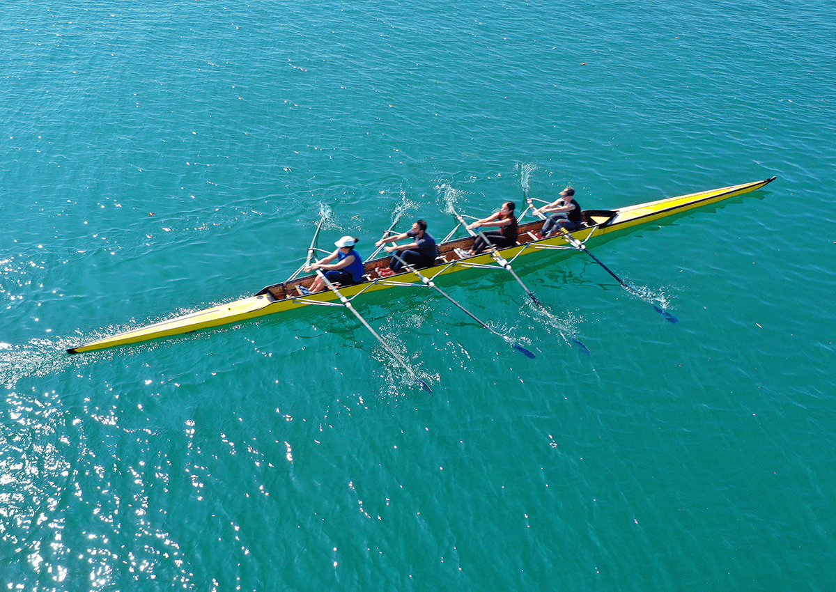 A team works together to paddle a canoe through a body of water.