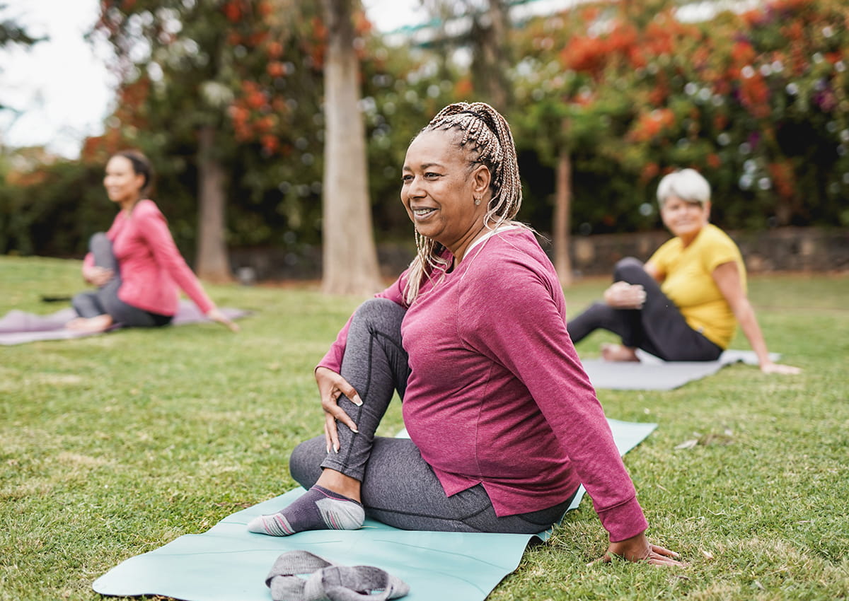 Middle-aged woman participates in an outdoor yoga class.