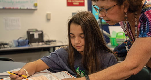 Teacher helping student with math lesson.